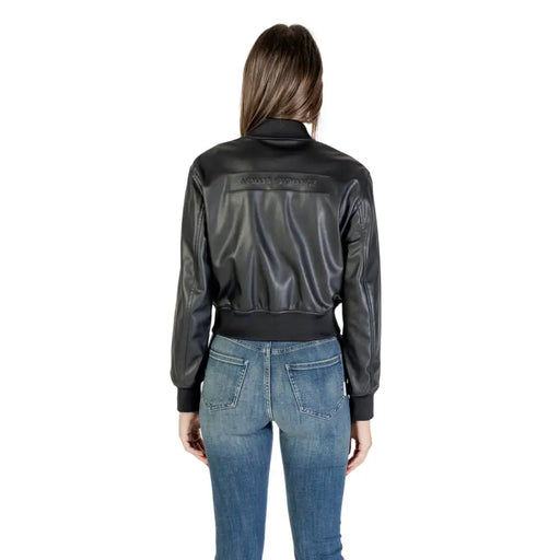 Women wearing Armani Exchange black leather bomber jacket with ribbed hem over blue jeans