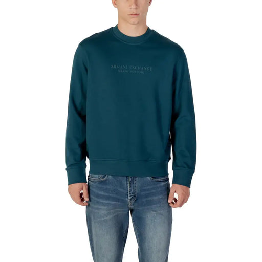 Men’s dark teal long-sleeve crewneck sweatshirt paired with blue jeans from Armani Exchange