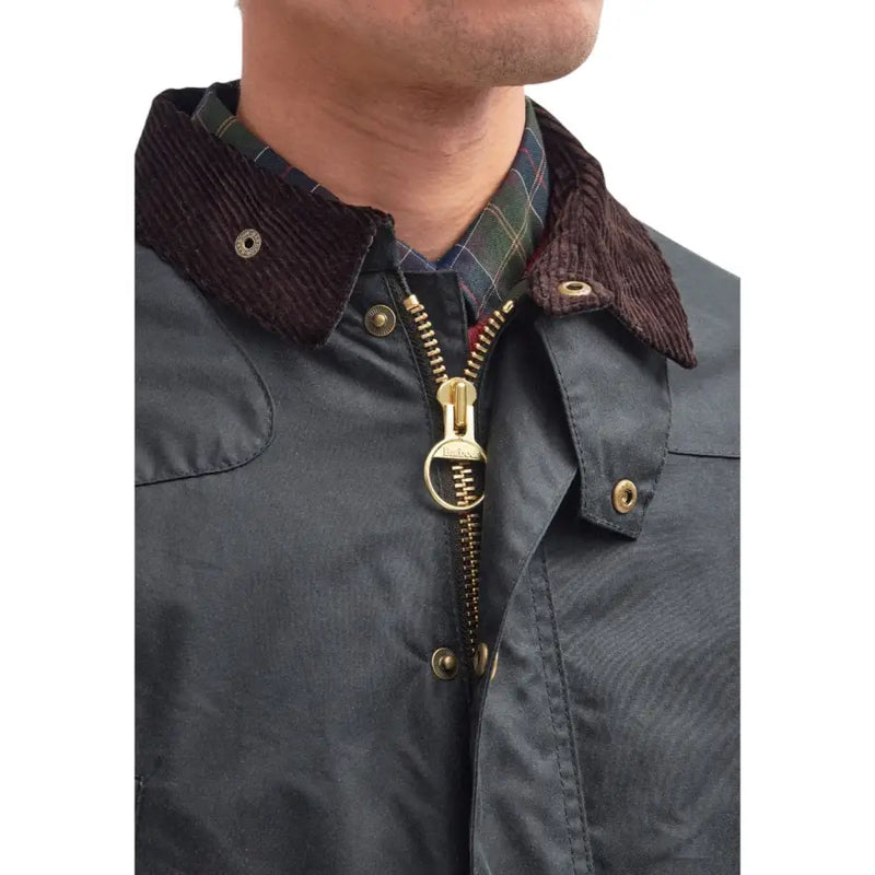 Man wearing a waxed cotton jacket with corduroy collar and brass zipper in Barbour Grey Cotton Blazer