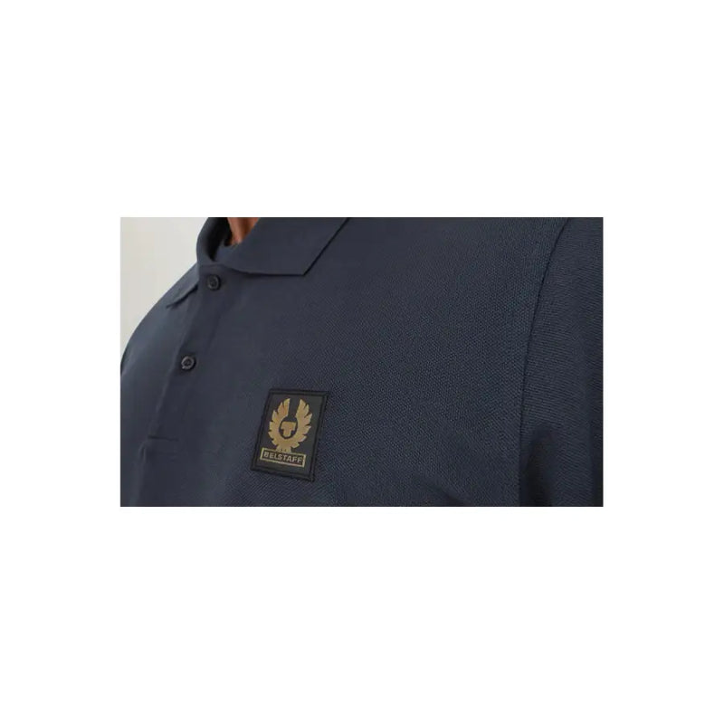 Navy blue polo shirt with gold logo and text, textured fabric.