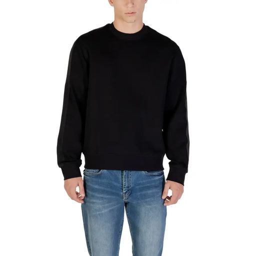 Black crewneck sweatshirt displayed on a product page in a sleek, modern setting