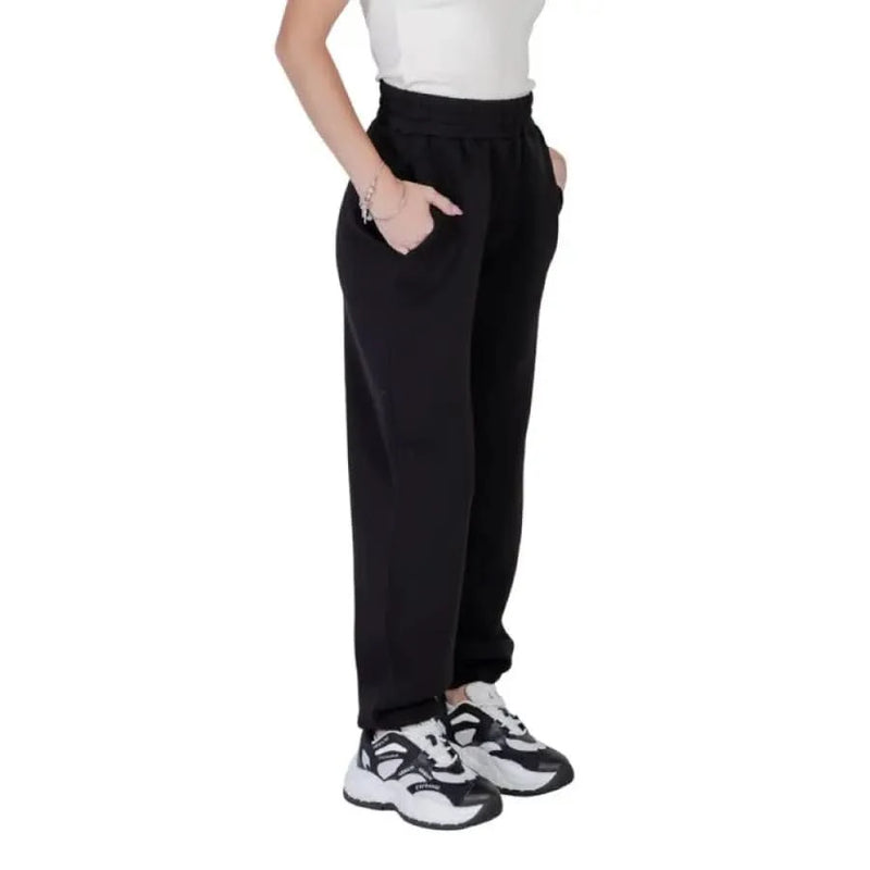Black elastic-waist sweatpants with side pockets and chunky athletic sneakers