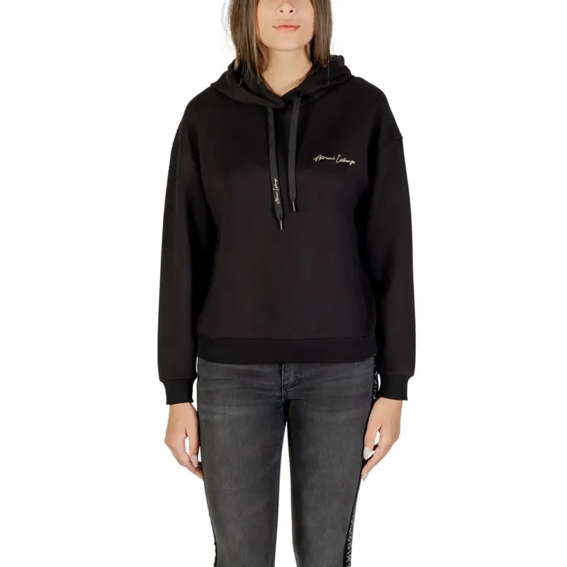 Black long-sleeved hoodie with drawstring and ribbed hem paired with dark grey skinny jeans
