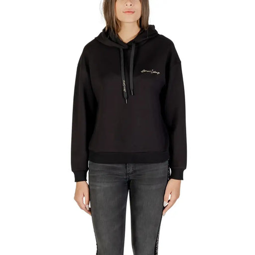 Black long-sleeved hoodie with drawstring and ribbed hem paired with dark grey skinny jeans