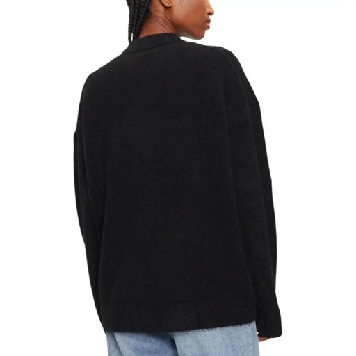 Black oversized knit sweater for women displayed in a fashion product image