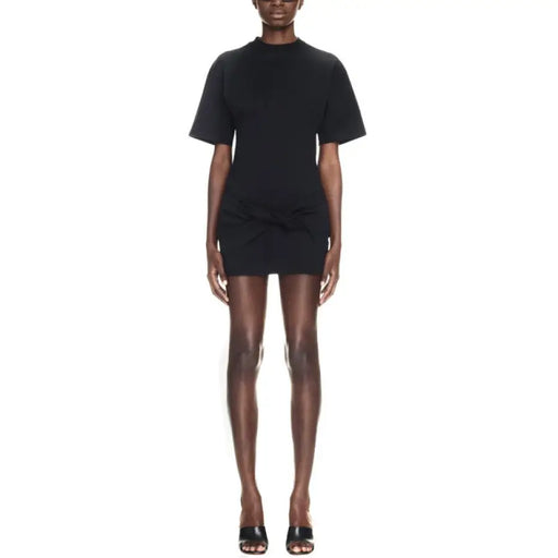 Black short-sleeved mini dress with knotted detail displayed with sculptural heels