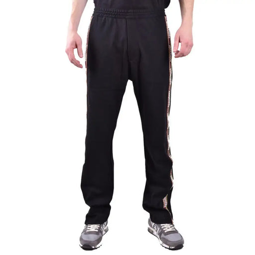 Black track pants with stylish side stripes displayed in the product listing