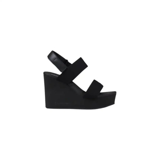 Black wedge sandal displayed in the product image showcasing stylish footwear