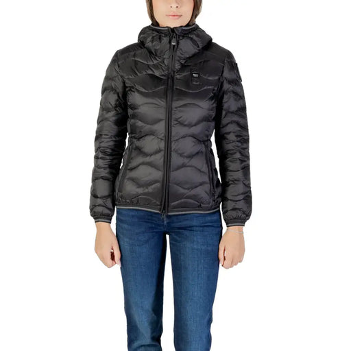 Women wearing a long black polyamide puffer jacket with hood, turtleneck, and blue jeans