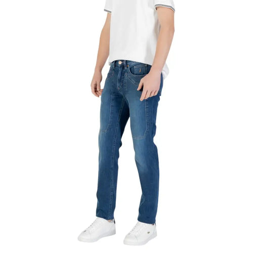 Man wearing blue denim jeans and white sneakers in a product display image