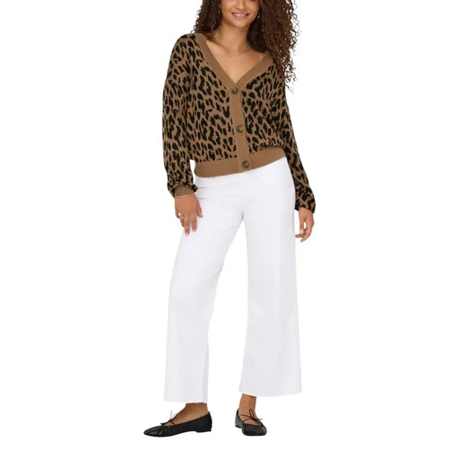 Woman wearing a brown leopard print cardigan with white wide-leg trousers and black ballet flats