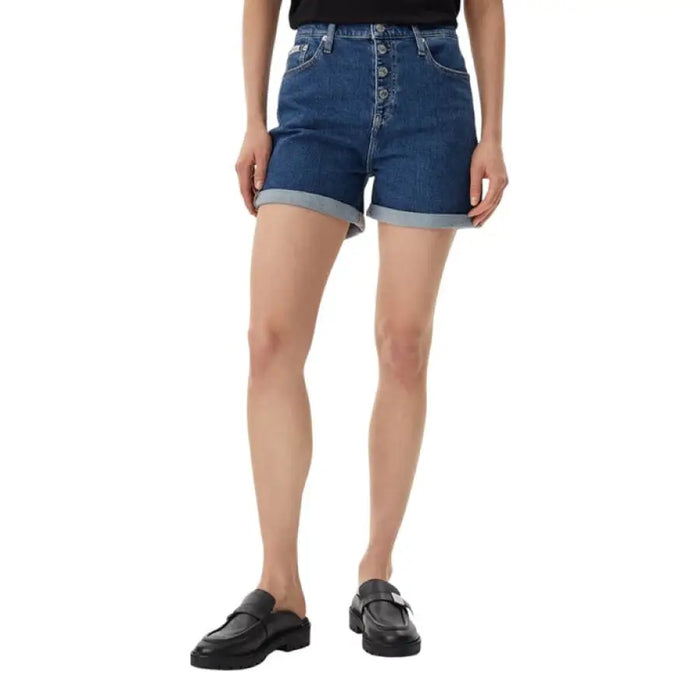 Woman wearing black T-shirt and denim button-fly shorts, stylish casual outfit