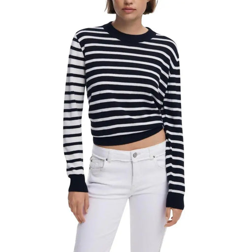 Woman wearing navy and white striped round neck knit sweater with white jeans