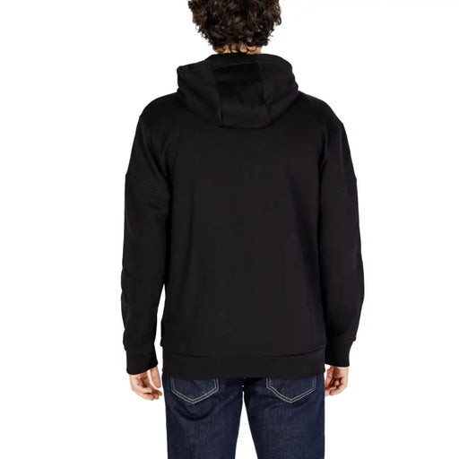 Men’s black hooded zip sweatshirt with long sleeves and ribbed cuffs paired with dark blue jeans