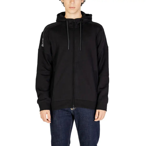 Man wearing EA7 Men Hooded Zip Sweatshirt in black with dark blue jeans
