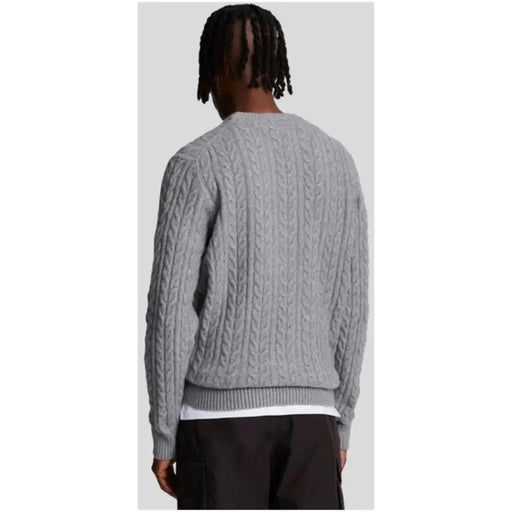Gray cable-knit sweater displayed as a stylish and comfortable fall wardrobe staple