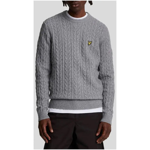 Gray cable knit sweater displayed as a stylish and comfortable winter apparel option