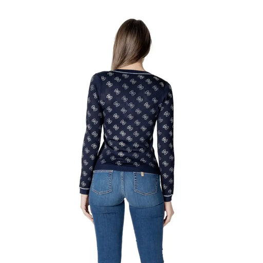 Woman from behind wearing Guess Blue V Neck Long Knitwear with patterned long-sleeved top and blue jeans