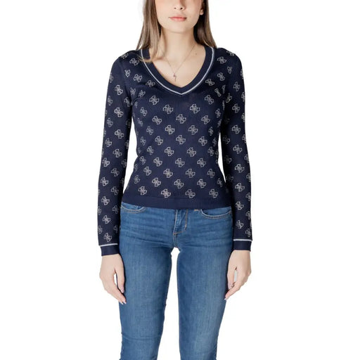 Woman wearing navy blue long-sleeve V-neck sweater with white pattern and trim