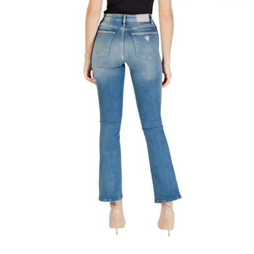 Women’s light wash blue flare jeans from Guess with zip and button closure and pockets