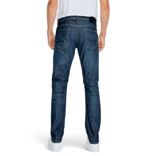 Dark blue slim fit jeans with distressed details and a classic five-pocket design.