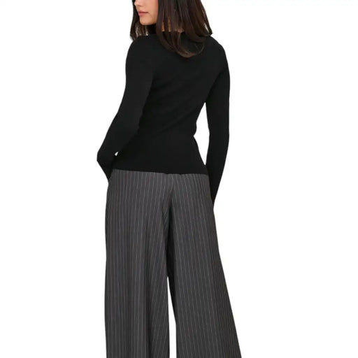 Women wearing Jacqueline De Yong long black round neck knit sweater with pinstriped wide-leg pants