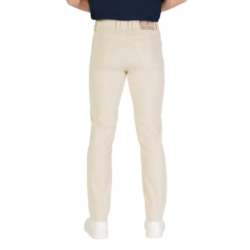 Beige golf pants with a slim fit and elastic waistband, likely made of cotton or polyester blend.