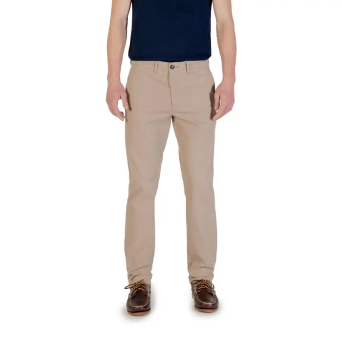 Khaki-colored men’s casual pants paired with brown boat shoes for a stylish look