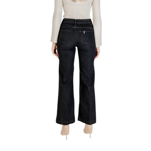 Woman wearing Liu Jo Women Black Zip Button Jeans with light long-sleeve top and nude heels
