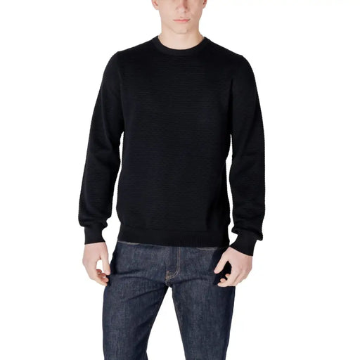 Man in black crewneck sweater and dark wash jeans displayed in product listing