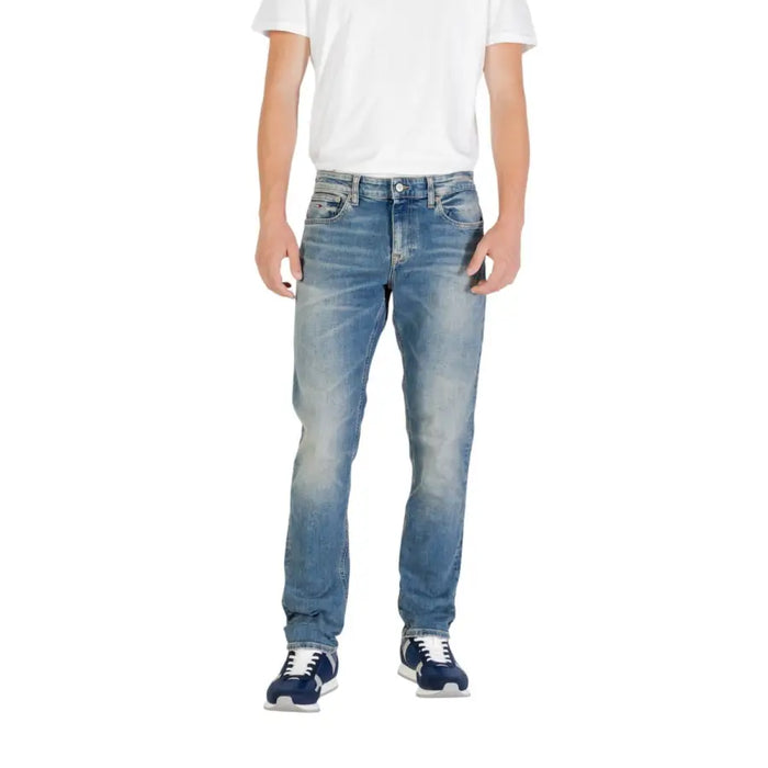 Man wearing light blue jeans and blue sneakers showcasing men’s fashion