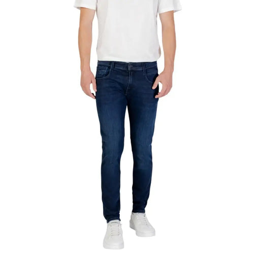 Man wearing dark blue slim fit jeans and white sneakers displayed in product listing