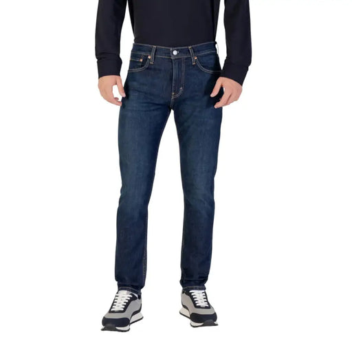 Man wearing Mens Dark Wash Denim Jeans modeled in a casual setting