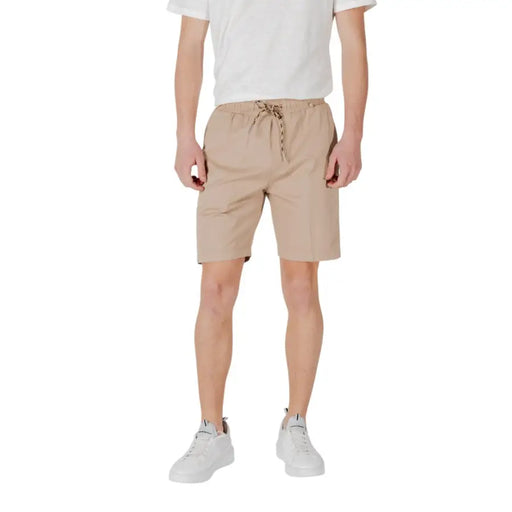 Man wearing Tan Drawstring Shorts and white sneakers in a casual outdoor setting