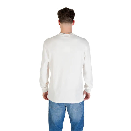 Man in long-sleeved white shirt and blue jeans for the product Man in Long Sleeve Shirt and Blue Jeans