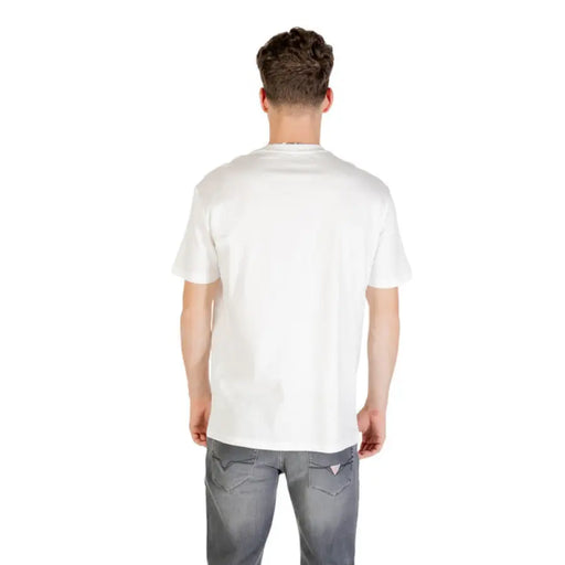 Man wearing a white Armani Exchange printed T shirt and gray jeans