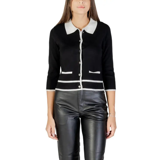Woman wearing Morgan De Toi black cardigan with white collar and leather pants