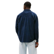 Man wearing dark blue long-sleeved shirt and light-wash jeans with Tommy Hilfiger blazer