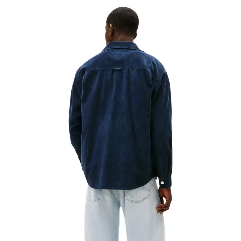 Man wearing dark blue long-sleeved shirt and light-wash jeans with Tommy Hilfiger blazer