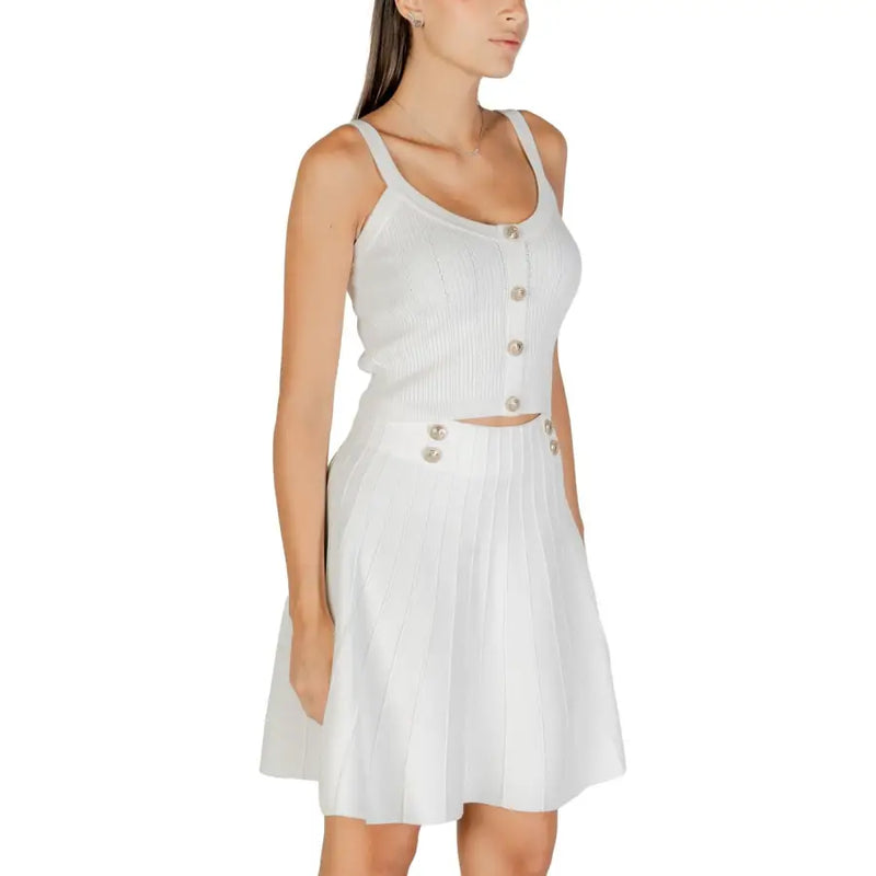 Guess White Strappy Round Neck Top paired with ribbed knit two-piece pleated skirt set with decorative buttons