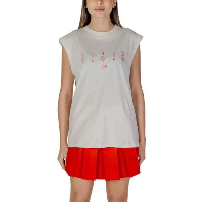 White sleeveless tank top with pink text design paired with a red pleated skirt