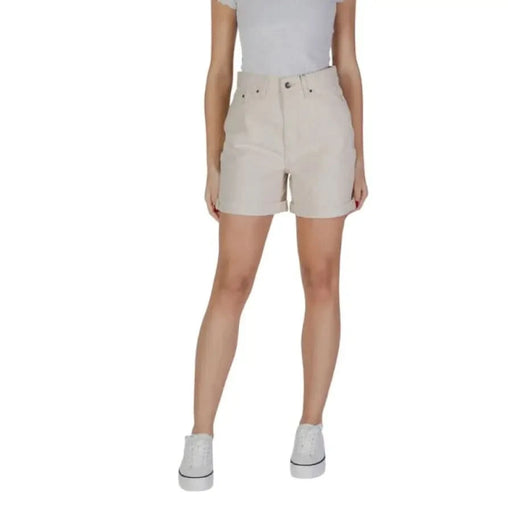 Woman in beige cotton shorts and white sneakers from B.young with pockets