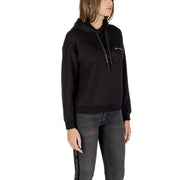 Woman wearing Armani Exchange black printed hooded sweatshirt and dark jeans
