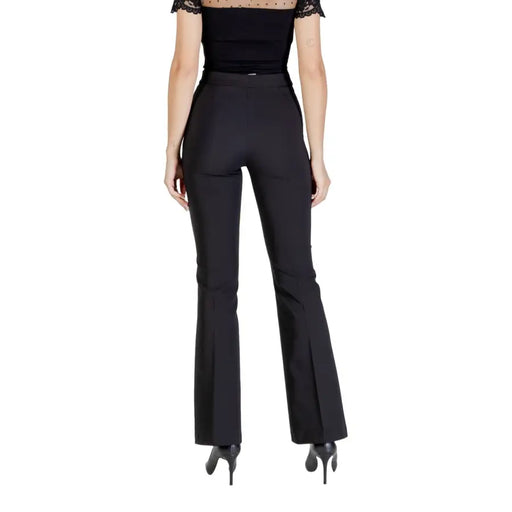 Woman wearing Rinascimento black fall winter trousers with pleats and a sheer dotted neckline top