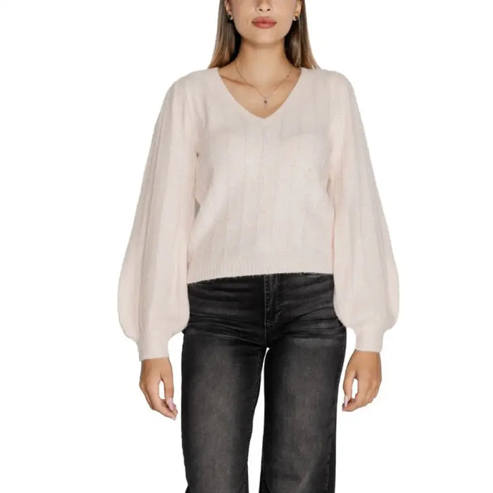 Woman wearing a cream-colored V-neck sweater with balloon sleeves from Women V Neck Sweater collection