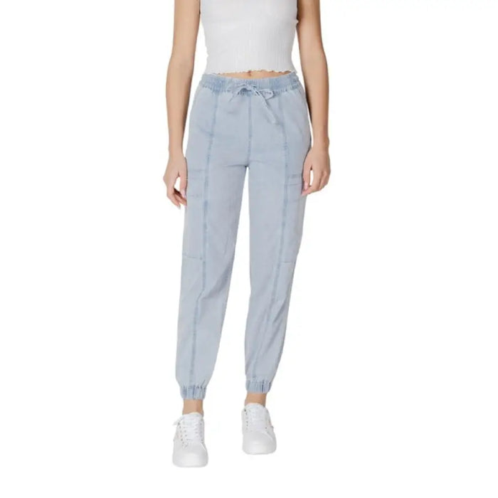 Woman wearing light blue drawstring jogger pants and white sneakers