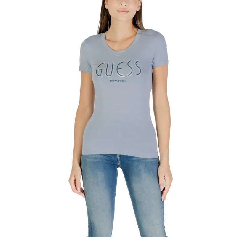 Woman wearing light blue Guess T-shirt and jeans for Fall Winter collection