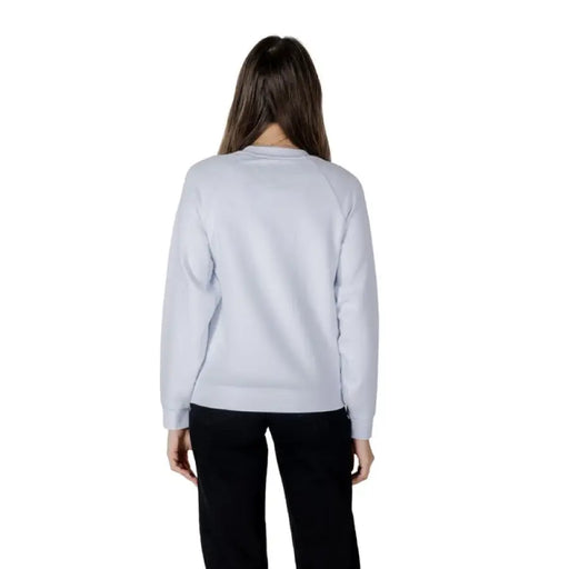 Woman wearing a light blue sweatshirt and black pants from Women’s Light Blue Sweatshirt and Black Pants collection