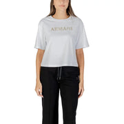 Woman wearing light grey Armani Exchange T shirt with gold lettering and black track pants