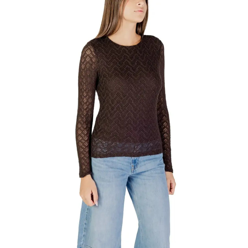 Woman wearing a dark brown sheer lace long-sleeve top and light blue wide-leg jeans